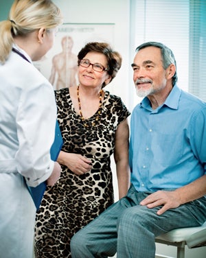 Happy couple talking to doctor